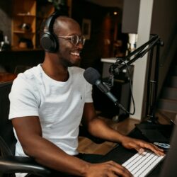 man in white crew neck t-shirt sitting on black office rolling chair