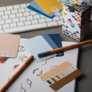 a desk with a keyboard, pencils, and various color samples