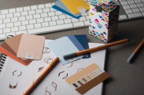 a desk with a keyboard, pencils, and various color samples